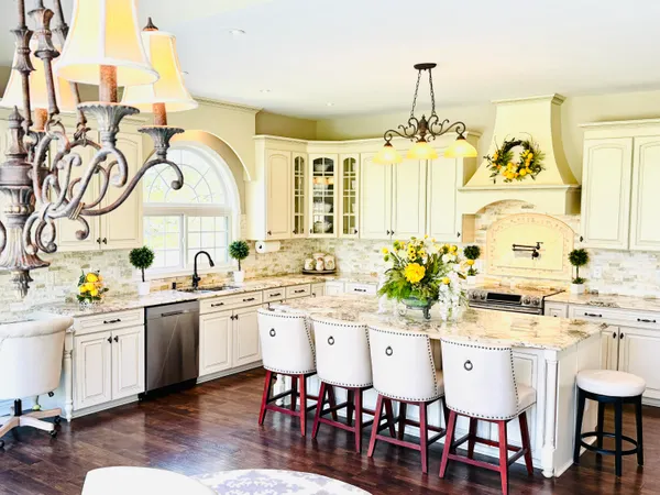 a large kitchen with granite countertop a stove a sink and a window