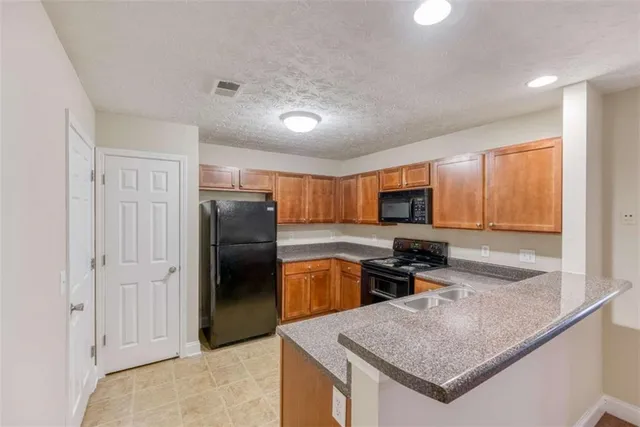 a kitchen with stainless steel appliances granite countertop a stove a sink and a refrigerator