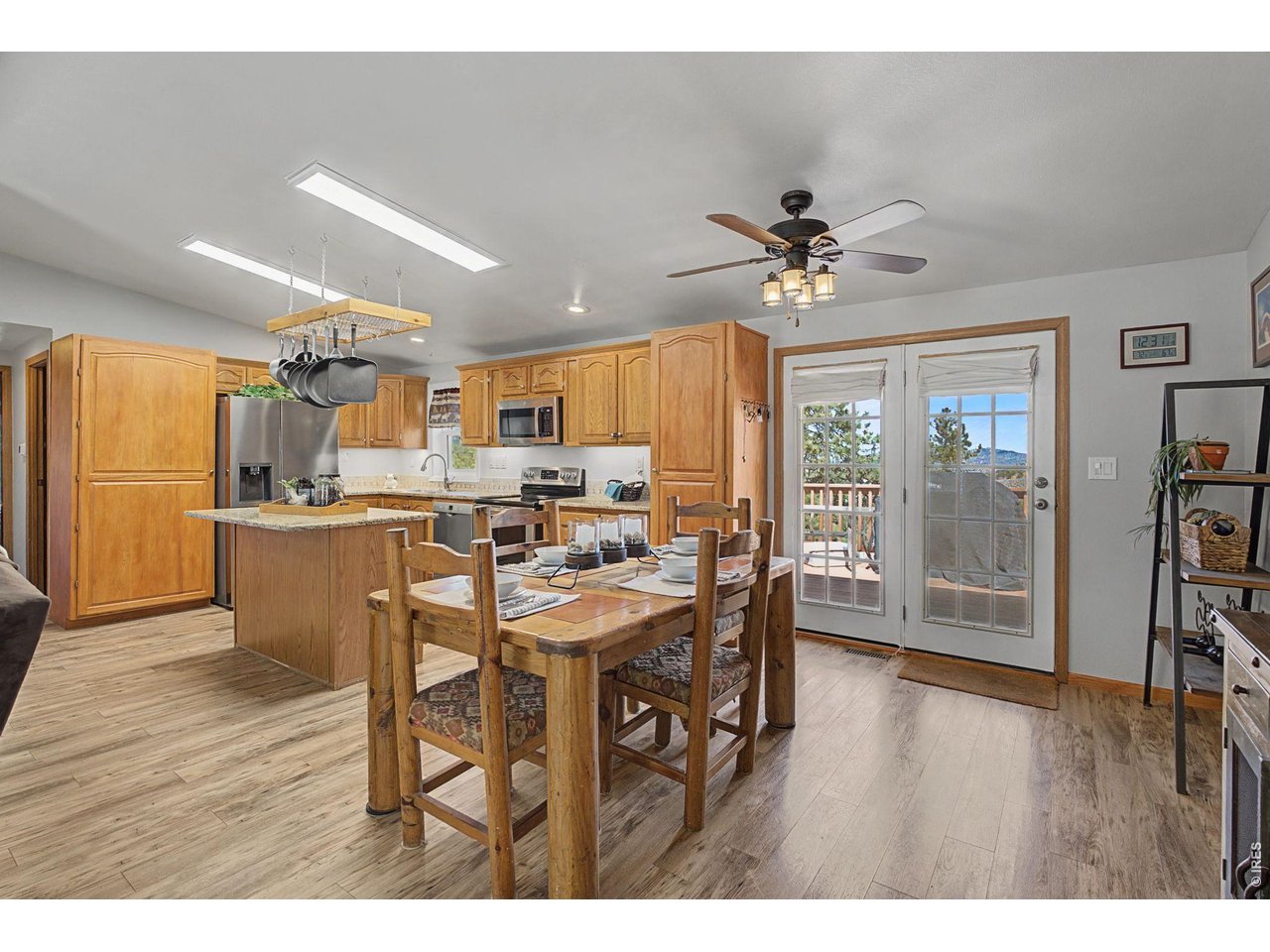 8701 Rock Hill Road Loveland, CO 80537 - Photo 15 of 50 a open kitchen with stainless steel appliances kitchen island granite countertop a table chairs and a refrigerator