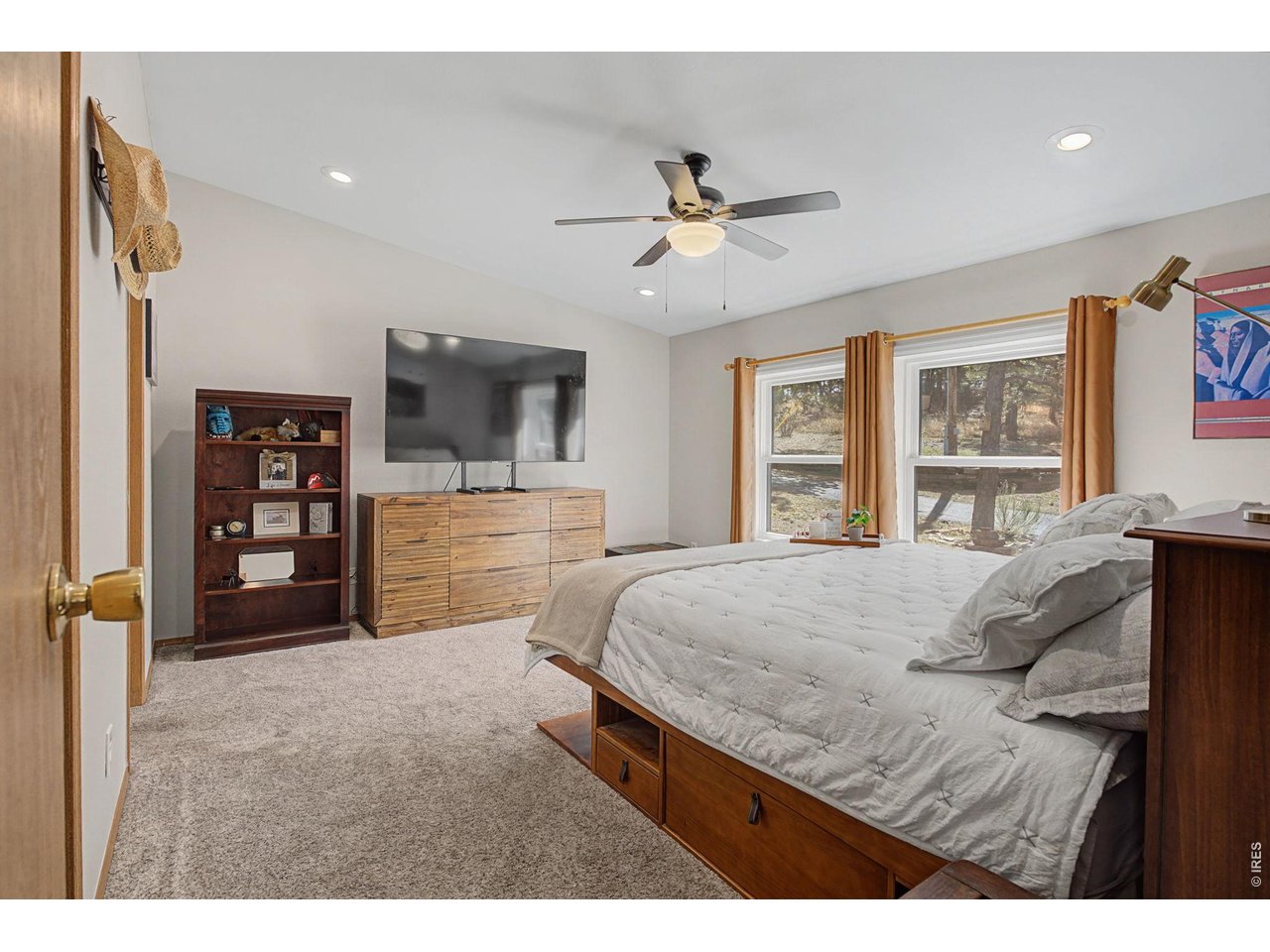 8701 Rock Hill Road Loveland, CO 80537 - Photo 19 of 50 a bedroom with a bed a dresser and a large window