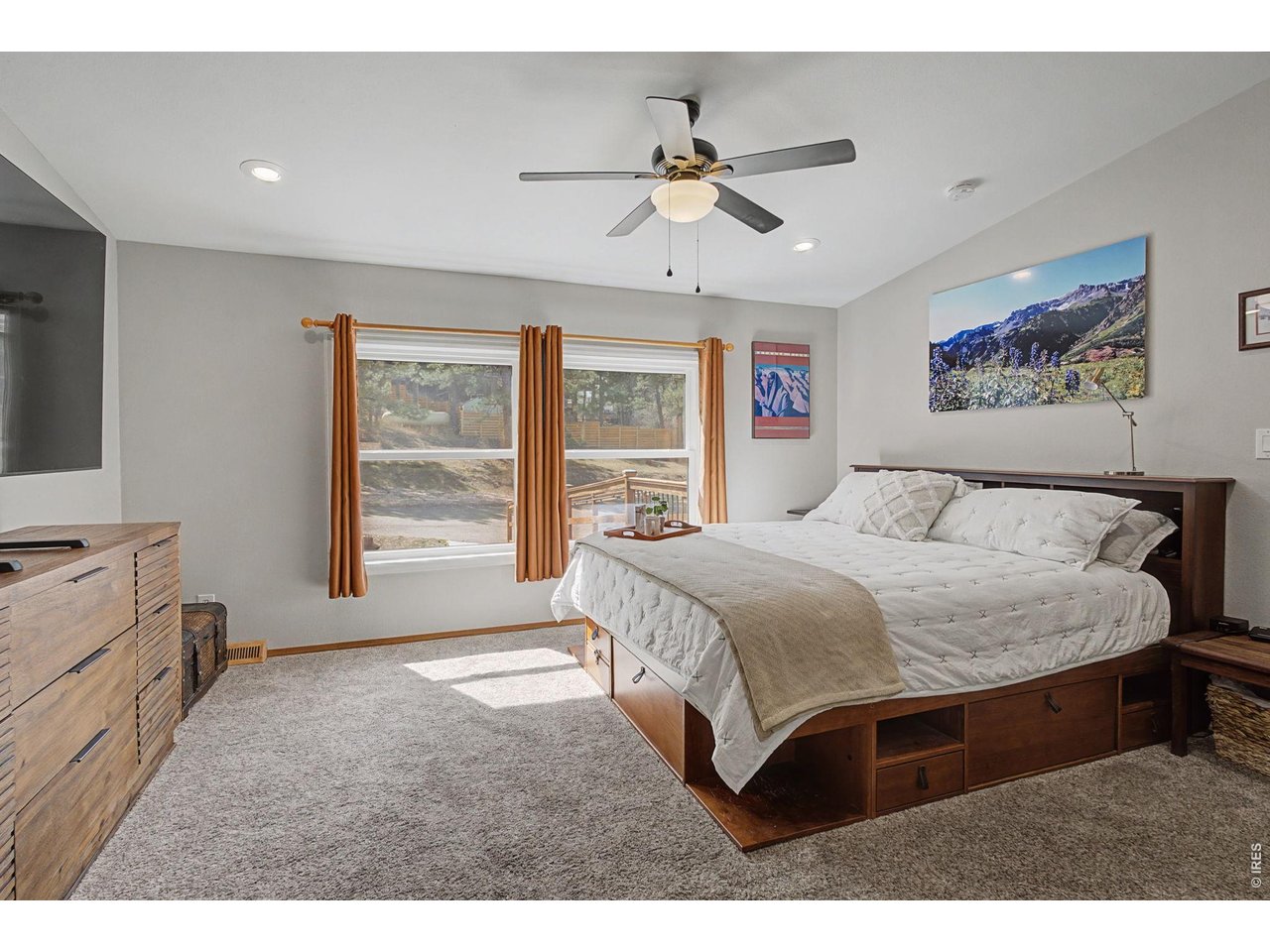 8701 Rock Hill Road Loveland, CO 80537 - Photo 20 of 50 a bedroom with a large bed and a chandelier