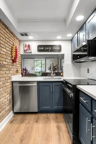 a kitchen with stainless steel appliances granite countertop a sink and a stove