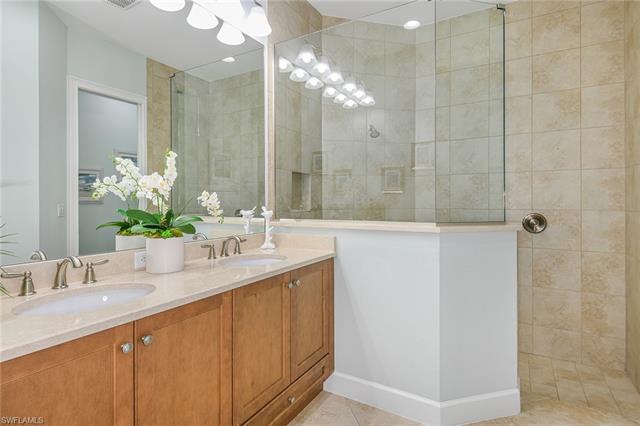 8777 Yucatan Court Naples, FL 34113 - Photo 15 of 41 a bathroom with a granite countertop sink a large mirror and a shower