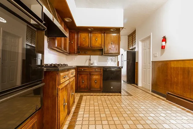 a kitchen with stainless steel appliances granite countertop a refrigerator a stove and a sink