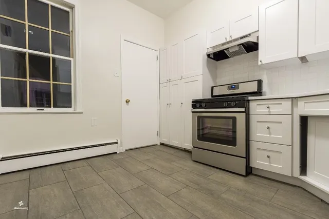a kitchen with cabinets and wooden floor