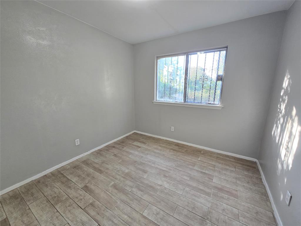 6108 Lazy River Drive Dallas, TX 75241 - Photo 12 of 16 an empty room with wooden floor and windows