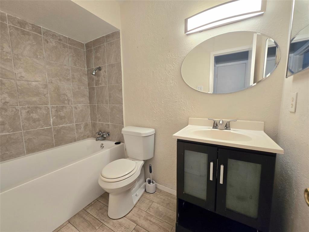 6108 Lazy River Drive Dallas, TX 75241 - Photo 14 of 16 a bathroom with a sink a toilet and a mirror