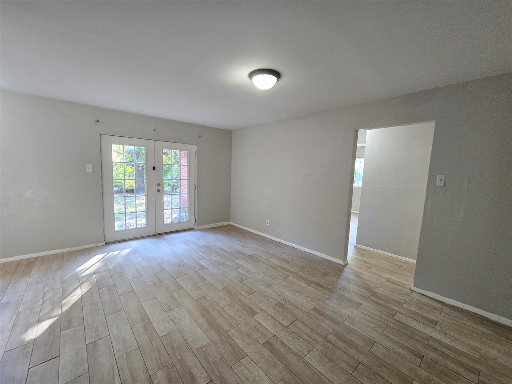 6108 Lazy River Drive Dallas, TX 75241 - Photo 5 of 16 an empty room with wooden floor and windows