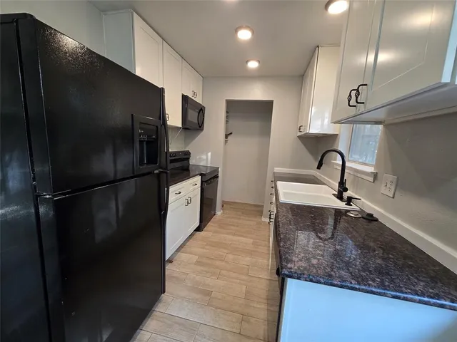 a kitchen with a refrigerator and a sink