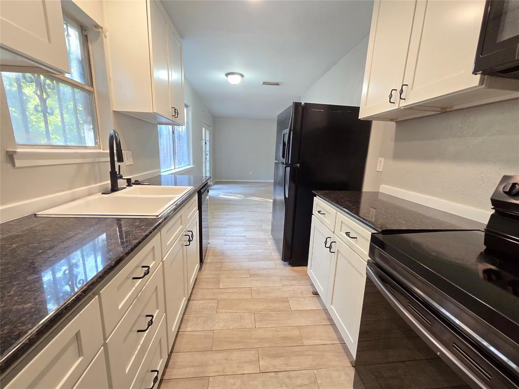 6108 Lazy River Drive Dallas, TX 75241 - Photo 8 of 16 a kitchen with granite countertop a refrigerator and a sink