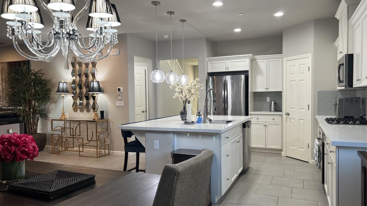 3525 Cordova Avenue Clovis, CA 93619 - Photo 11 of 35 a kitchen with a sink dishwasher a refrigerator and a dining table with wooden floor