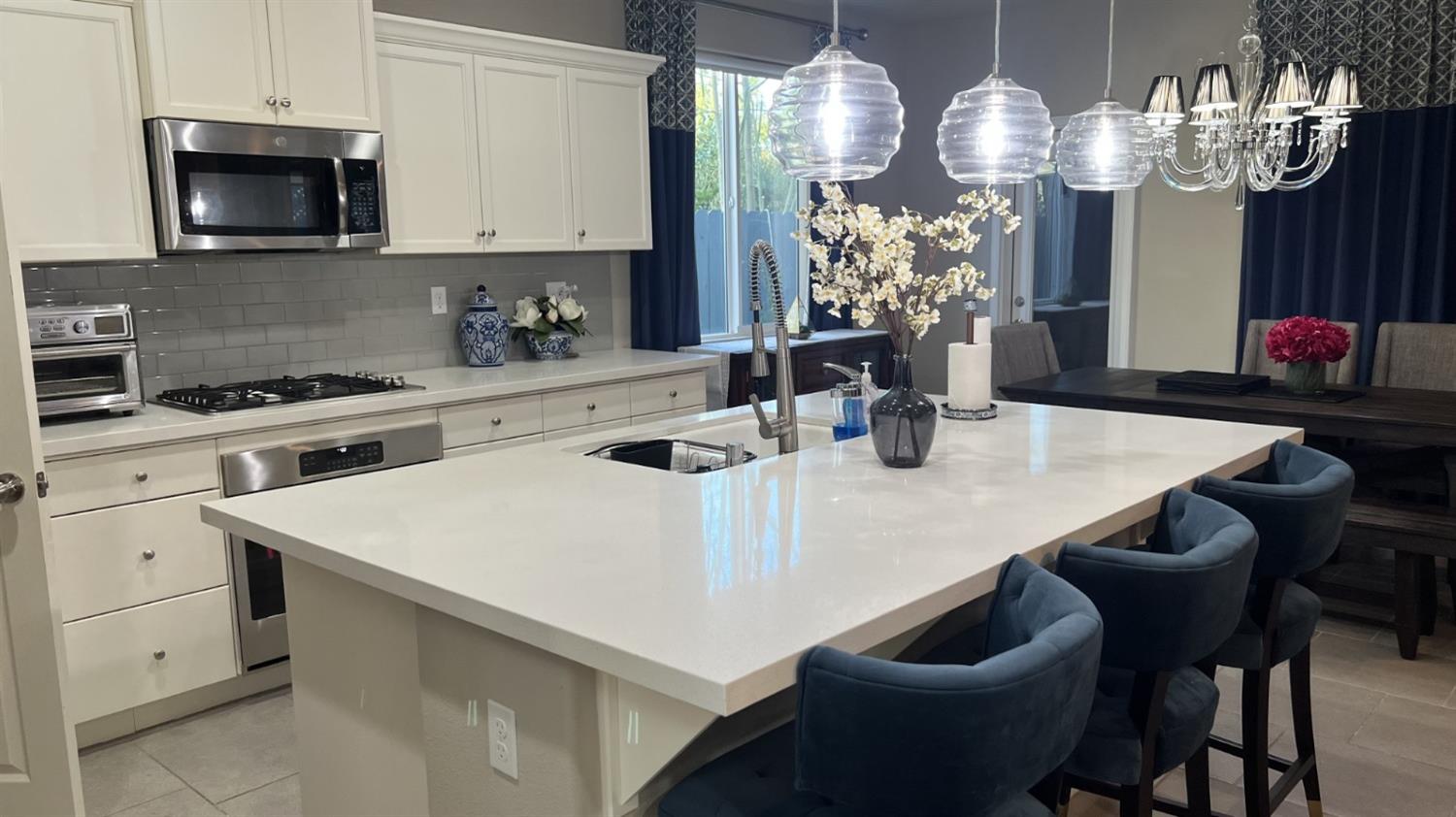 3525 Cordova Avenue Clovis, CA 93619 - Photo 8 of 35 a kitchen with stainless steel appliances a dining table a sink and cabinets