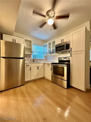 a kitchen with stainless steel appliances a refrigerator a stove top oven a sink and a refrigerator