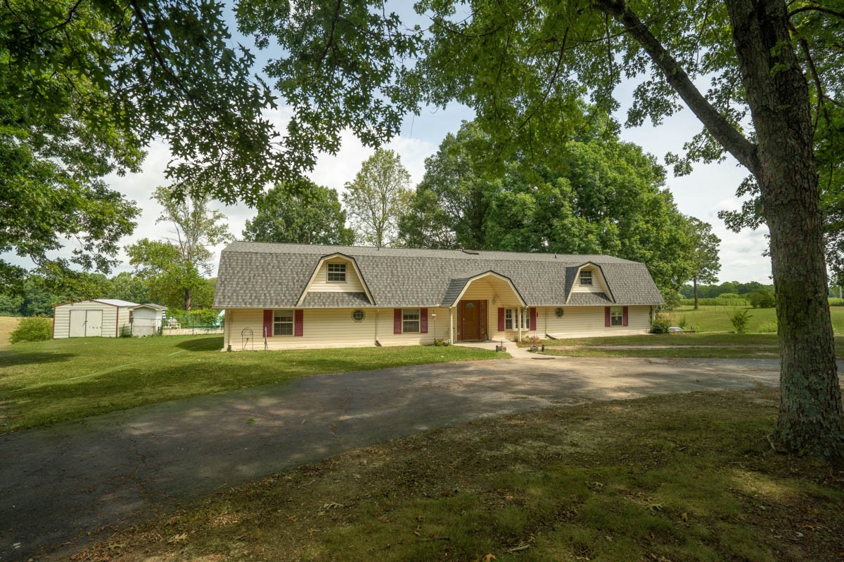 1157 Morgan Road Lafayette, TN 37083 - Photo 2 of 45 a front view of a house with a yard garage and trees