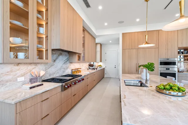 a large kitchen with stainless steel appliances a stove a sink and a window