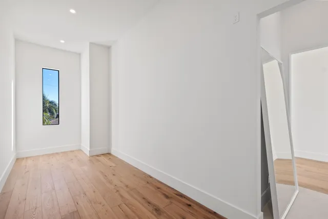 an empty room with wooden floor and entrance