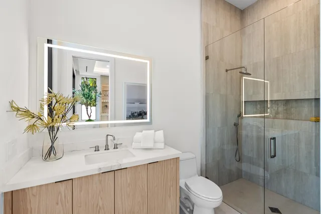 a bathroom with a granite countertop sink a toilet and shower
