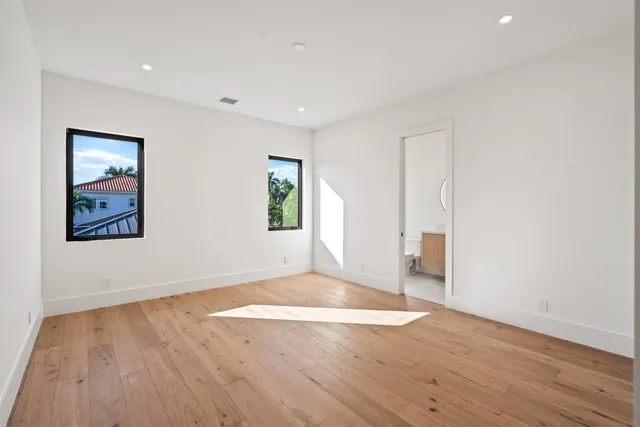 an empty room with wooden floor and window