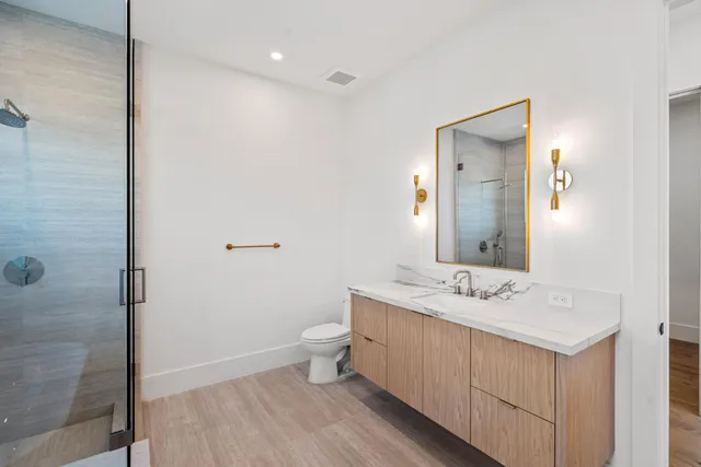 a bathroom with a sink a toilet and shower