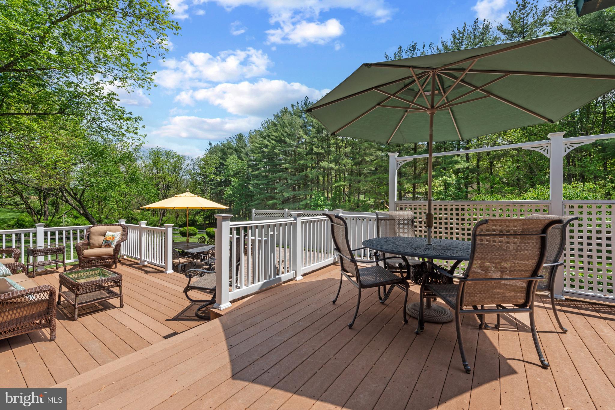 832 Muller Road Westminster, MD 21157 - Photo 23 of 39 a view of a roof deck with table and chairs under an umbrella with wooden floor
