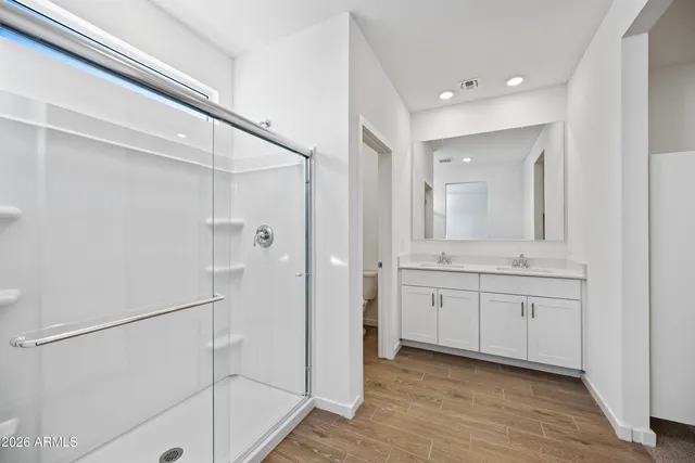 a bathroom with a double vanity sink toilet and shower