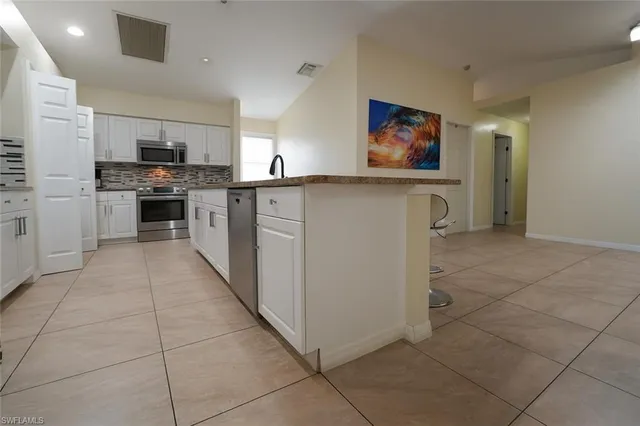 a kitchen with stainless steel appliances a stove refrigerator and a microwave