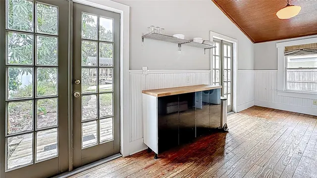 a living room with stainless steel appliances wooden floor and a large window