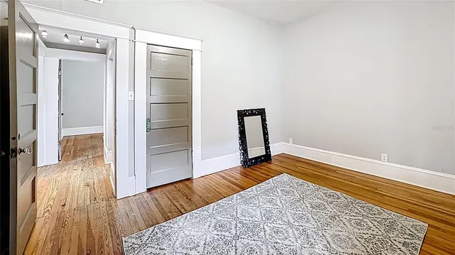 a view of a room with wooden floor and a rug