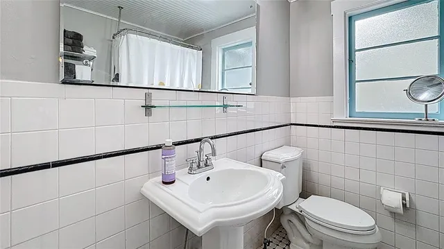 a bathroom with a sink a toilet and mirror