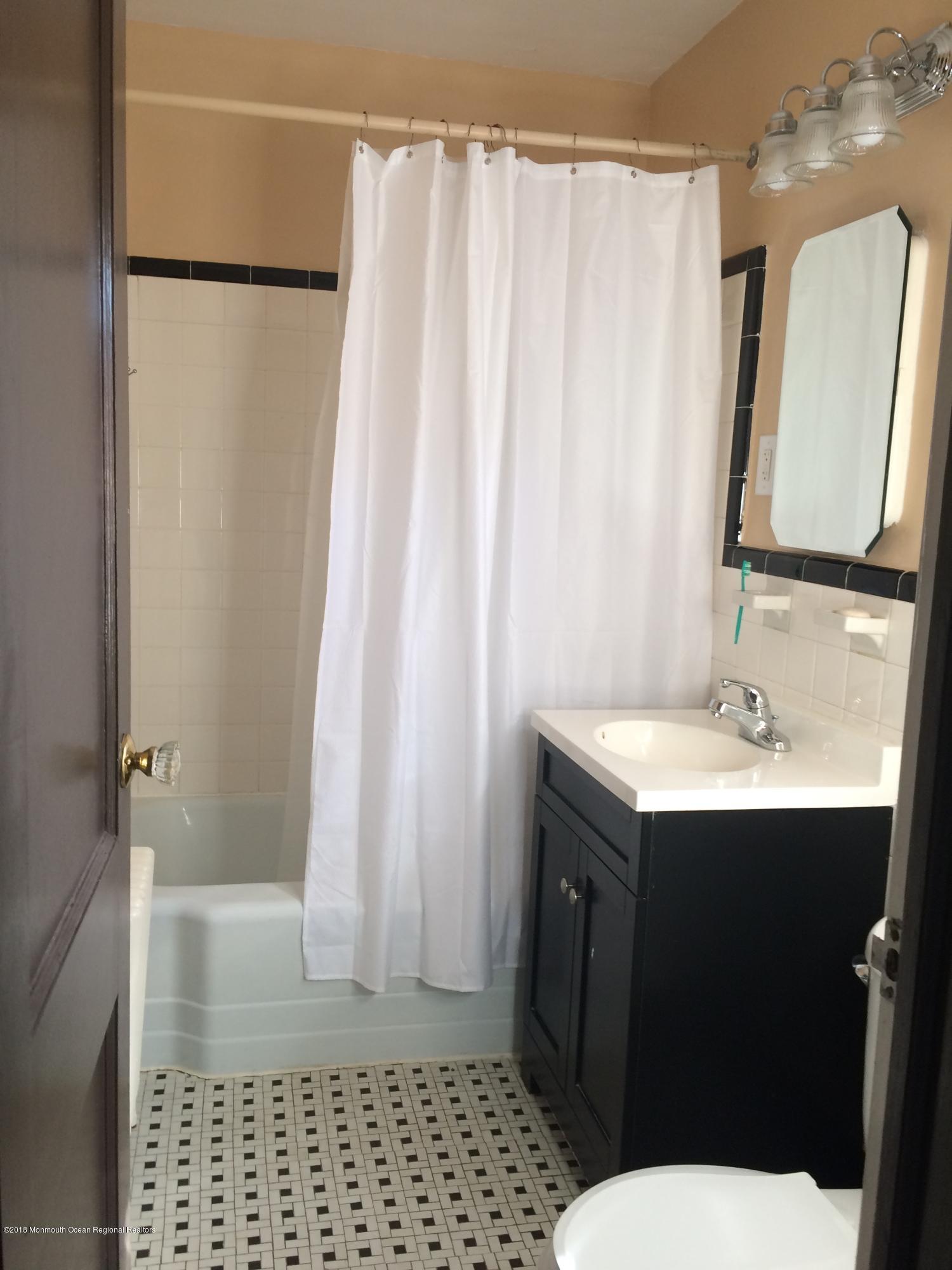 22 Pinckney Road, Unit C Red Bank, NJ 07701 - Photo 13 of 13 a bathroom with a sink a toilet a mirror and shower