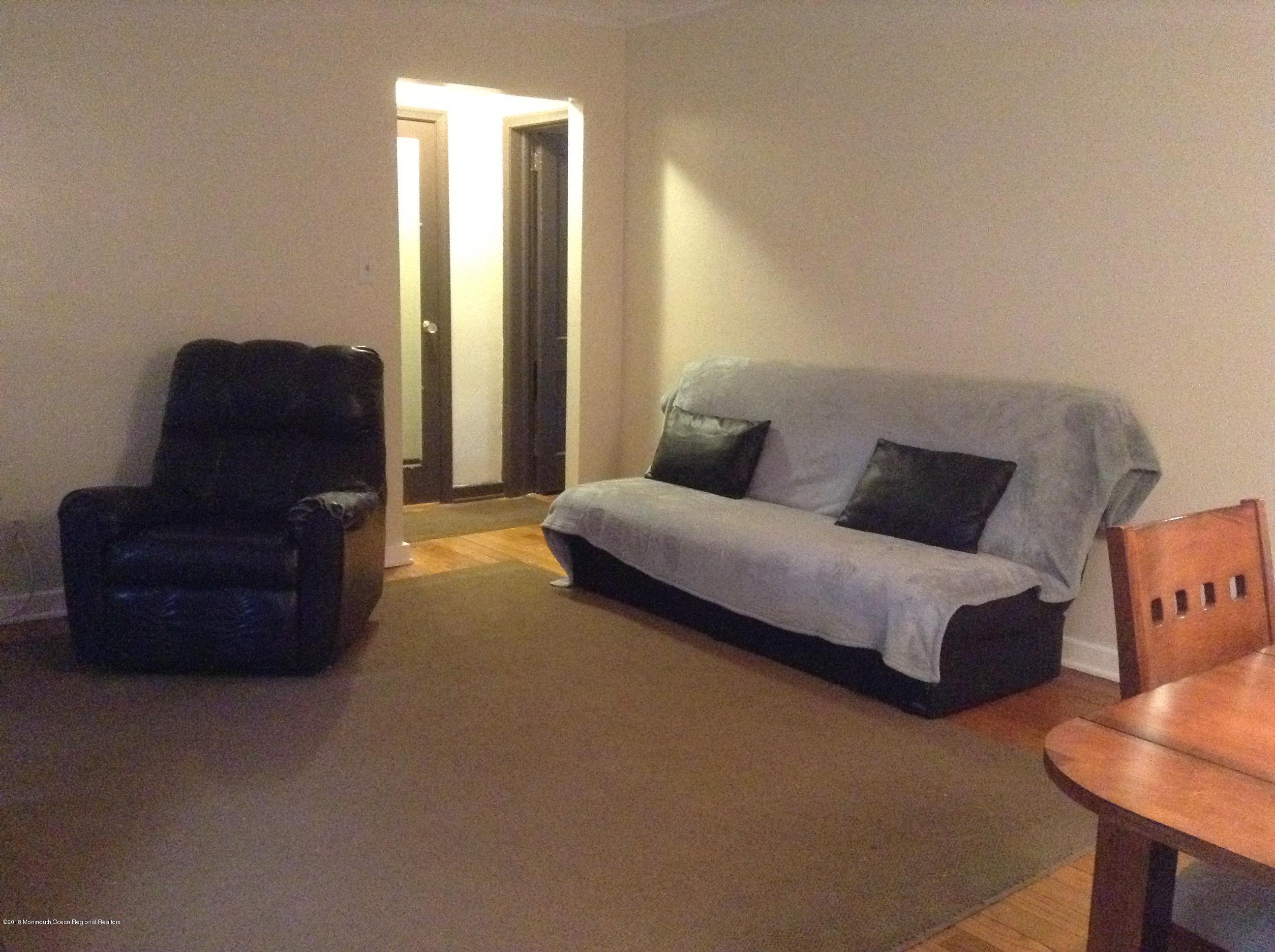 22 Pinckney Road, Unit C Red Bank, NJ 07701 - Photo 10 of 13 a living room with couches and a bookshelf with wooden floor