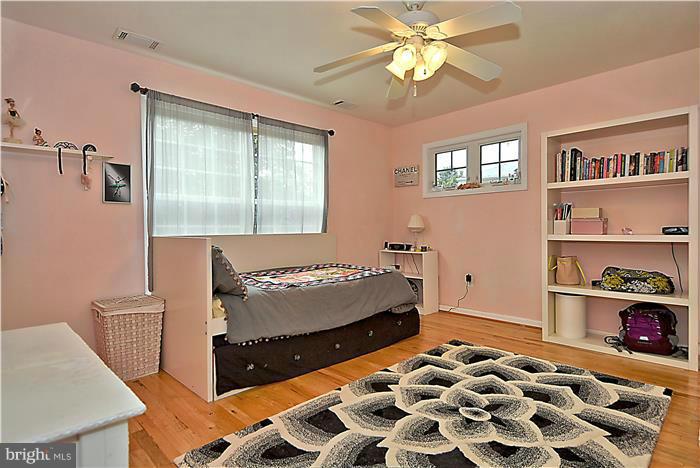8731 Ridge Road Bethesda, MD 20817 - Photo 19 of 29 a bedroom with a bed and a chandelier