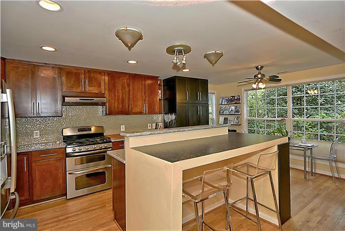 8731 Ridge Road Bethesda, MD 20817 - Photo 8 of 29 a kitchen with granite countertop stainless steel appliances and wooden cabinets
