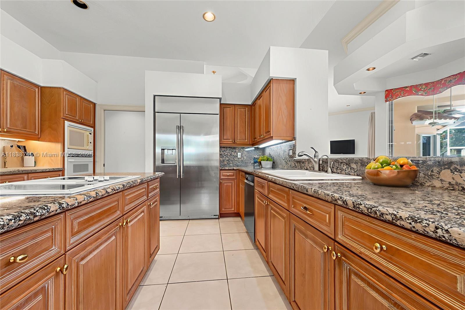 3833 Pine Lake Drive Weston, FL 33332 - Photo 23 of 46 a kitchen with stainless steel appliances granite countertop a sink stove and refrigerator