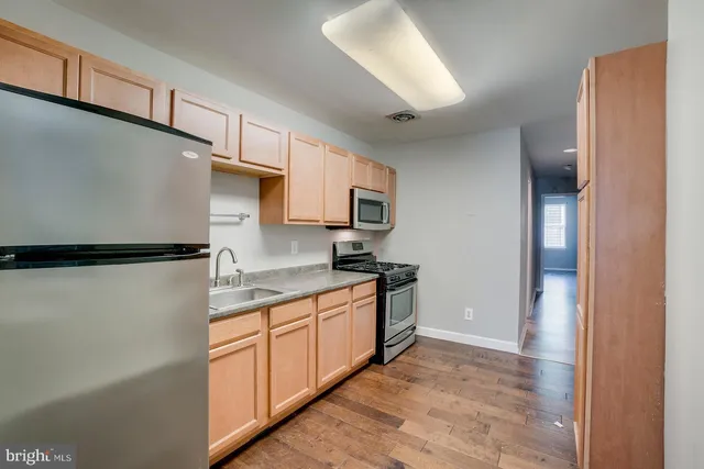 a kitchen with stainless steel appliances granite countertop a refrigerator a stove and a sink