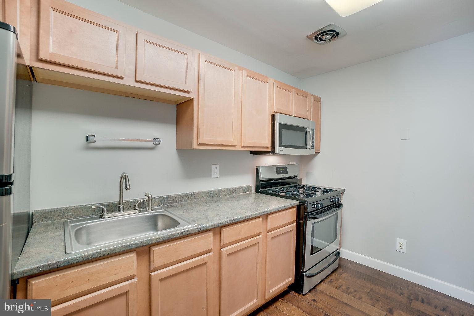 1522 East Baltimore Street, Unit 1 Baltimore, MD 21231 - Photo 15 of 26 a kitchen with stainless steel appliances granite countertop a sink stove and microwave