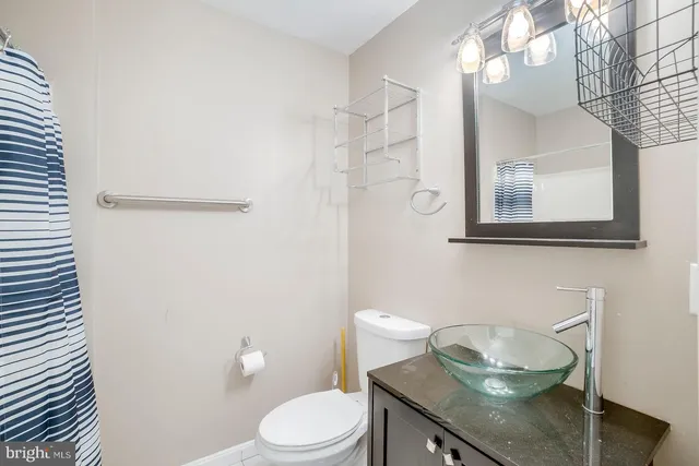 a bathroom with a granite countertop toilet sink and mirror