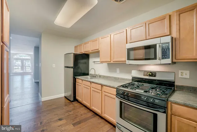 a kitchen with stainless steel appliances granite countertop a stove microwave and refrigerator