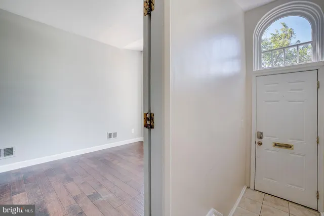 an empty room with window wooden floor and garden view