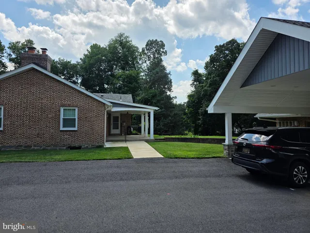 a view of backyard of house and car parked