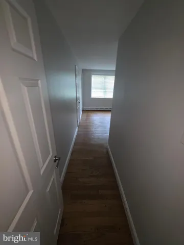 a view of hallway with wooden floor