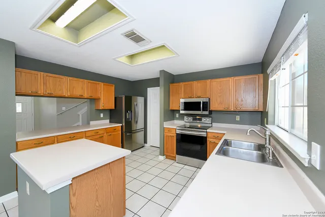 a kitchen with stainless steel appliances a stove a sink and a refrigerator