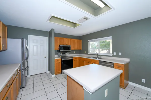 a kitchen with stainless steel appliances granite countertop a sink a stove and refrigerator
