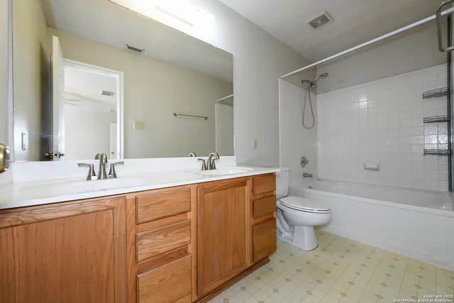 a bathroom with a double vanity sink toilet and shower