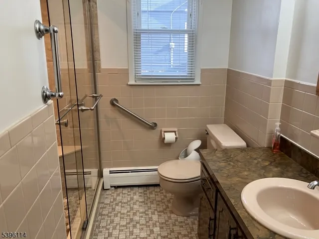 a bathroom with a granite countertop toilet sink and mirror