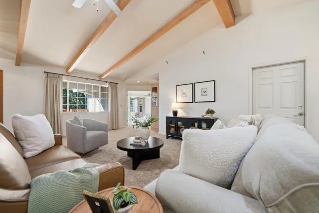 a living room with furniture a fireplace and a large window