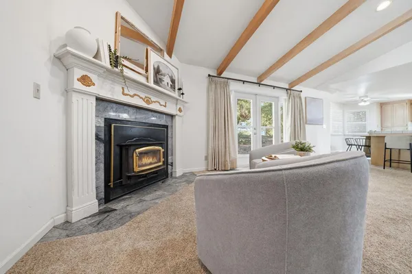 a kitchen with kitchen island a stove a sink and white cabinets