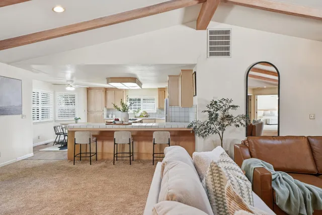 a kitchen with stainless steel appliances granite countertop a dining table chairs microwave and sink