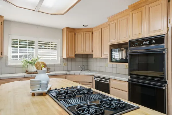 a kitchen with a stove a sink and a window