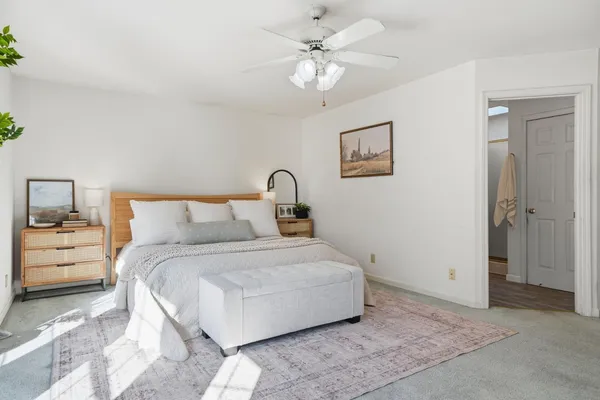 a view of an empty room with chandelier fan